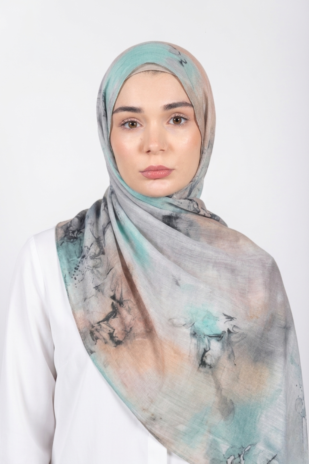 Woman wearing a patterned modal hijab against a white background