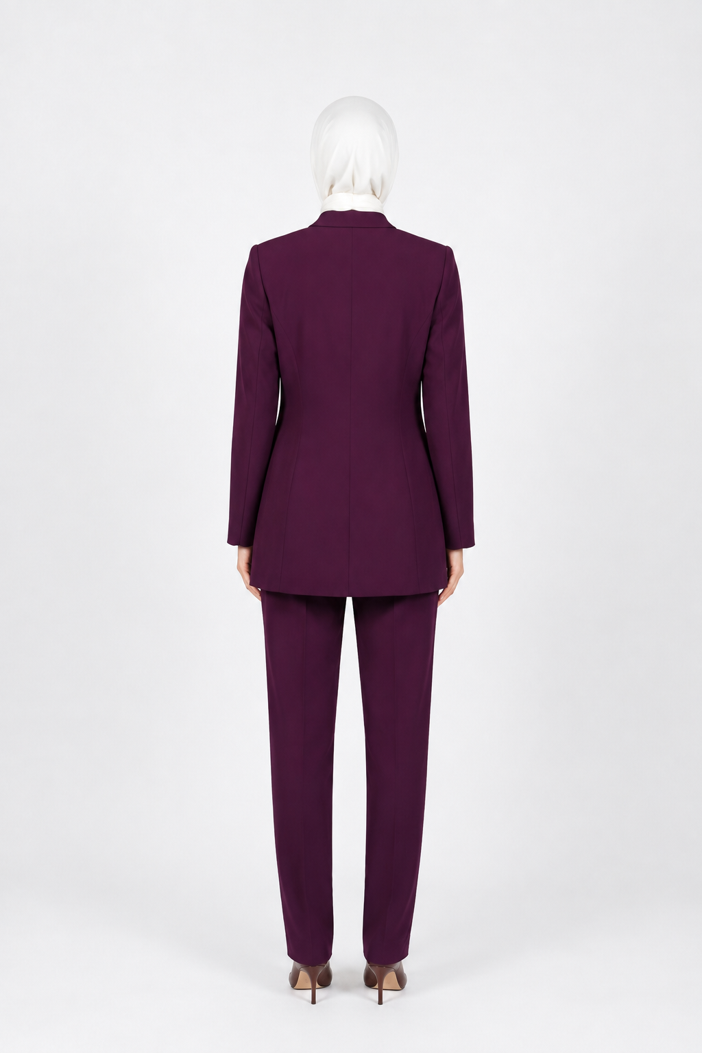 A person wearing a matching deep purple tailored suit, shown from the back against a plain light gray studio background.