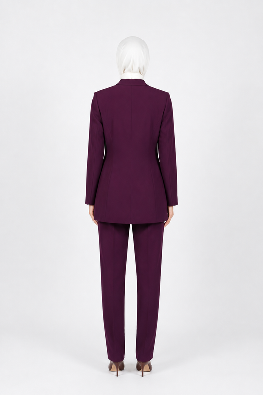 A person wearing a matching deep purple tailored suit, shown from the back against a plain light gray studio background.