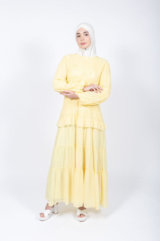 Woman wearing a yellow outfit on a white background