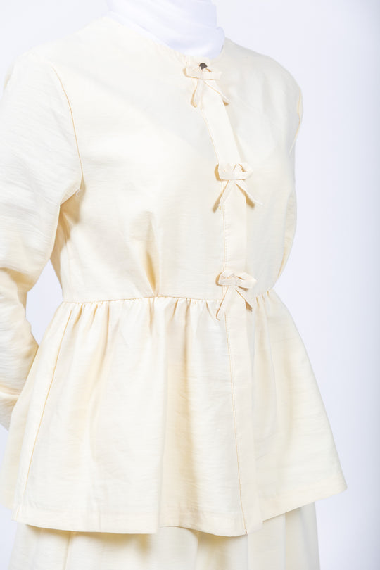 Light yellow dress with bow details on a white background