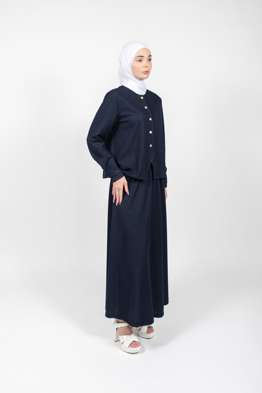 Woman wearing a navy blue outfit with a hijab on a white background