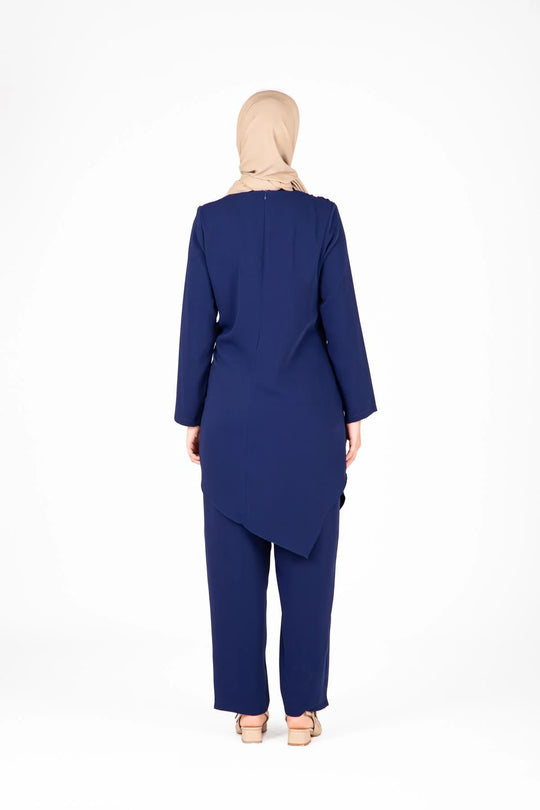 Woman wearing a blue outfit with a hijab on a white background